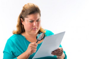 Woman looking through magnifying glass or loupe